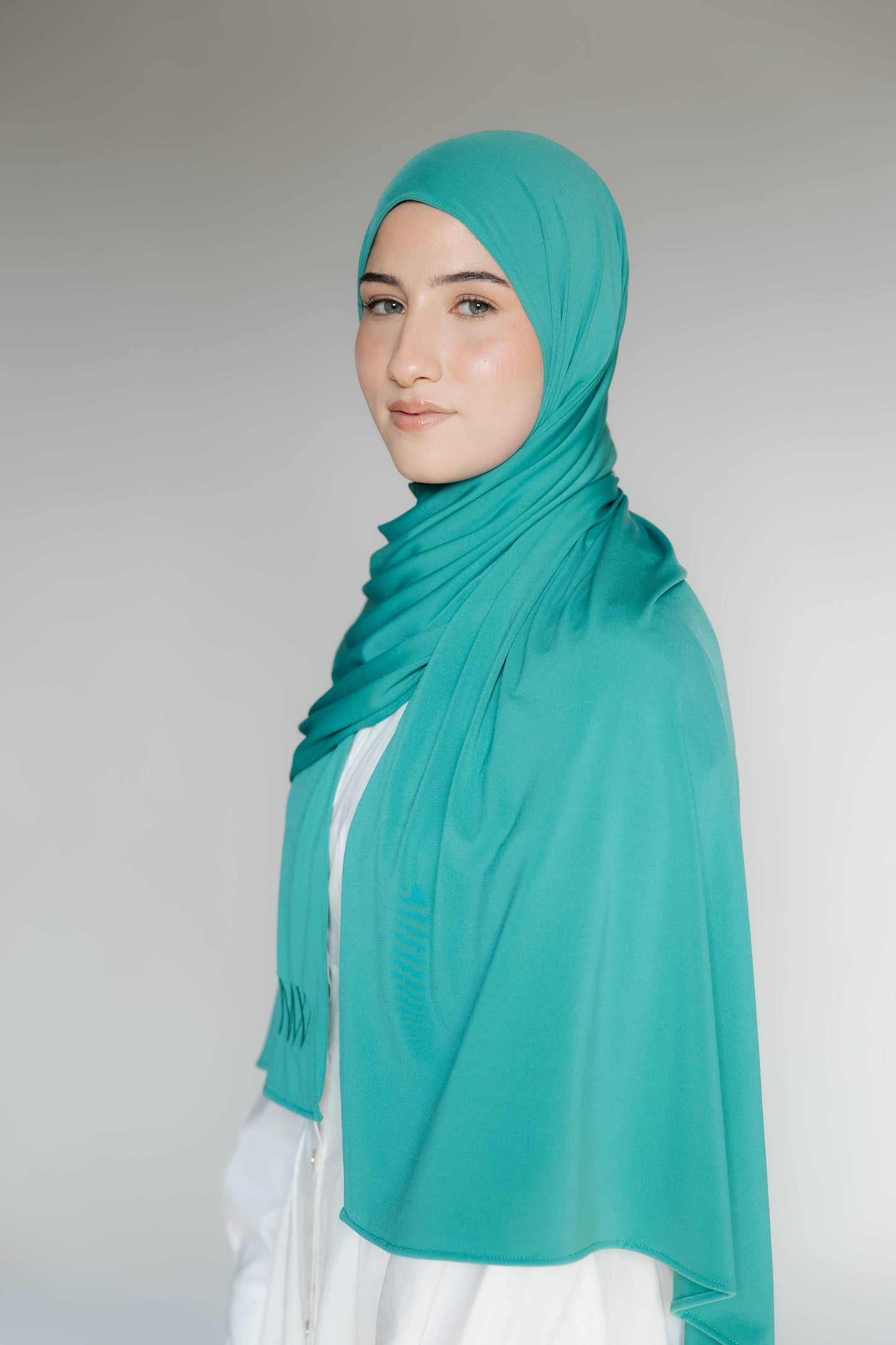 Model wearing a premium jersey hijab in turqouise color by Naleya Wear