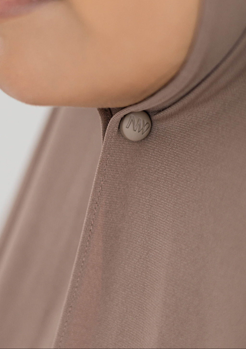 Close-up model wearing Naleya wear logo brown hijab magnets with strong hold on brown premium jersey scarf