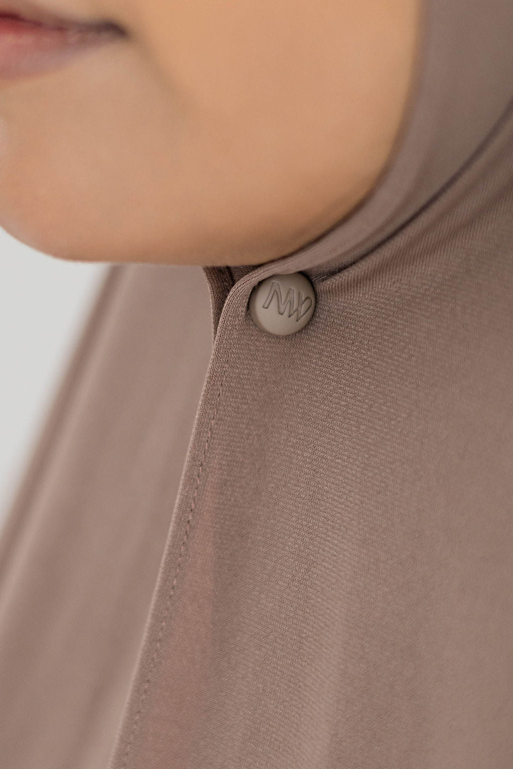 Close-up model wearing Naleya wear logo brown hijab magnets with strong hold on brown premium jersey scarf