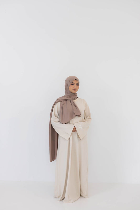 Model wearing eco-friendly abaya dress made of Sorona bio-cotton, lightweight and breathable material in color beige and brown premium jersey scarf naleya wear