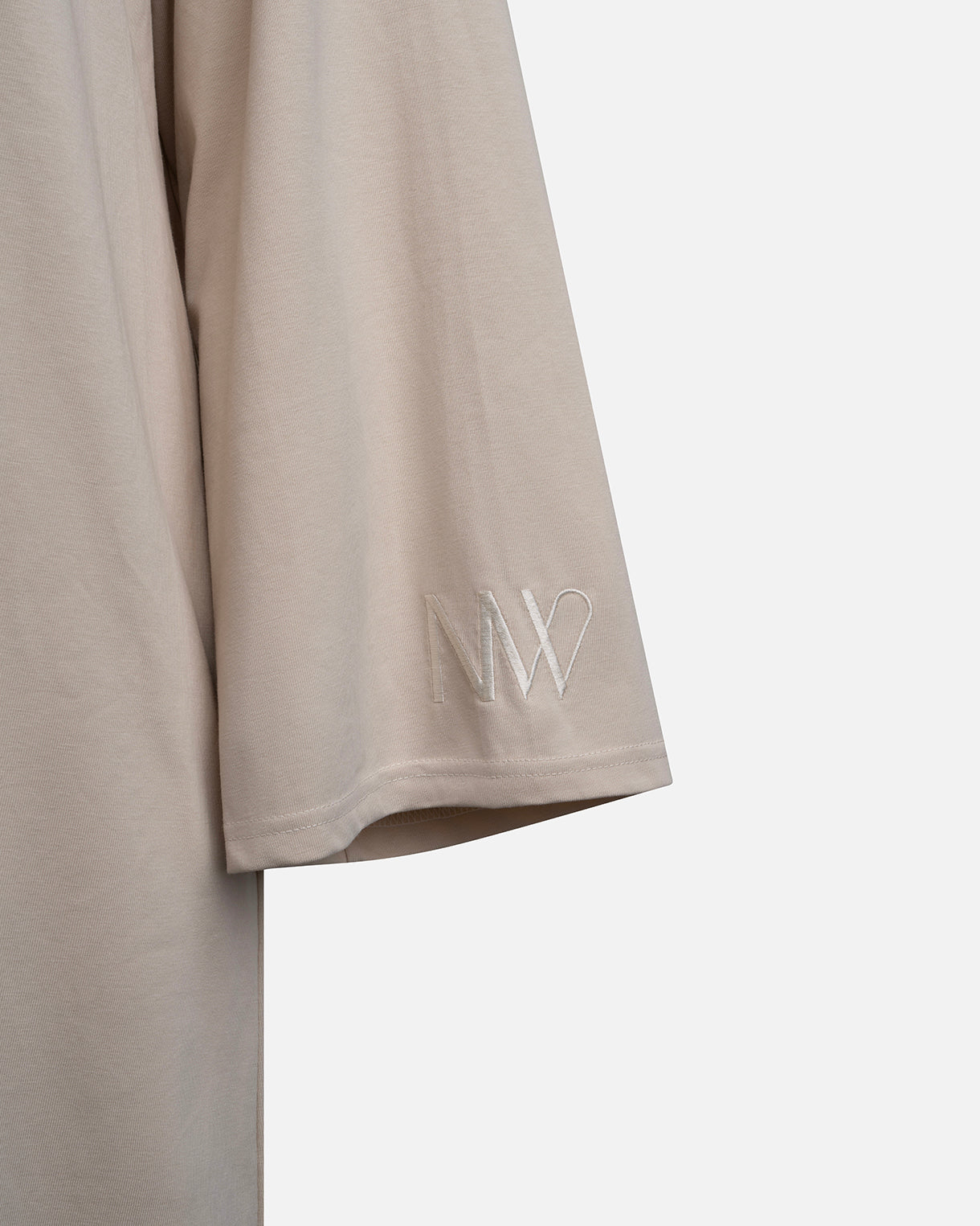 Eco-friendly abaya dress made of Sorona bio-cotton, lightweight and breathable material in color beige, close up naleya wear logo displayed on a neutral background