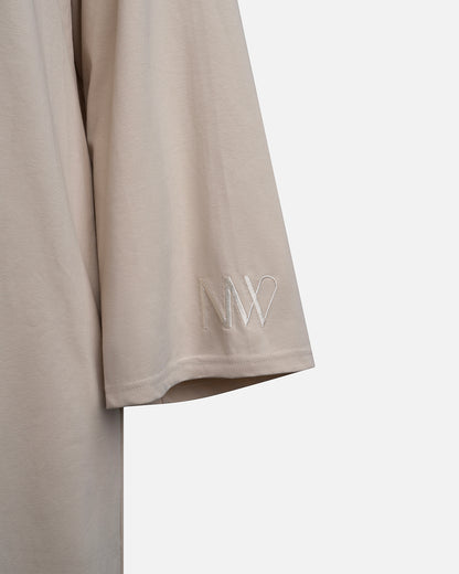 Eco-friendly abaya dress made of Sorona bio-cotton, lightweight and breathable material in color beige, close up naleya wear logo displayed on a neutral background