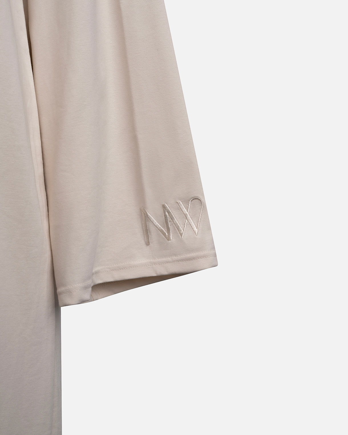 Eco-friendly abaya dress made of Sorona bio-cotton, lightweight and breathable material in color off white, close up naleya wear logo displayed on a neutral background