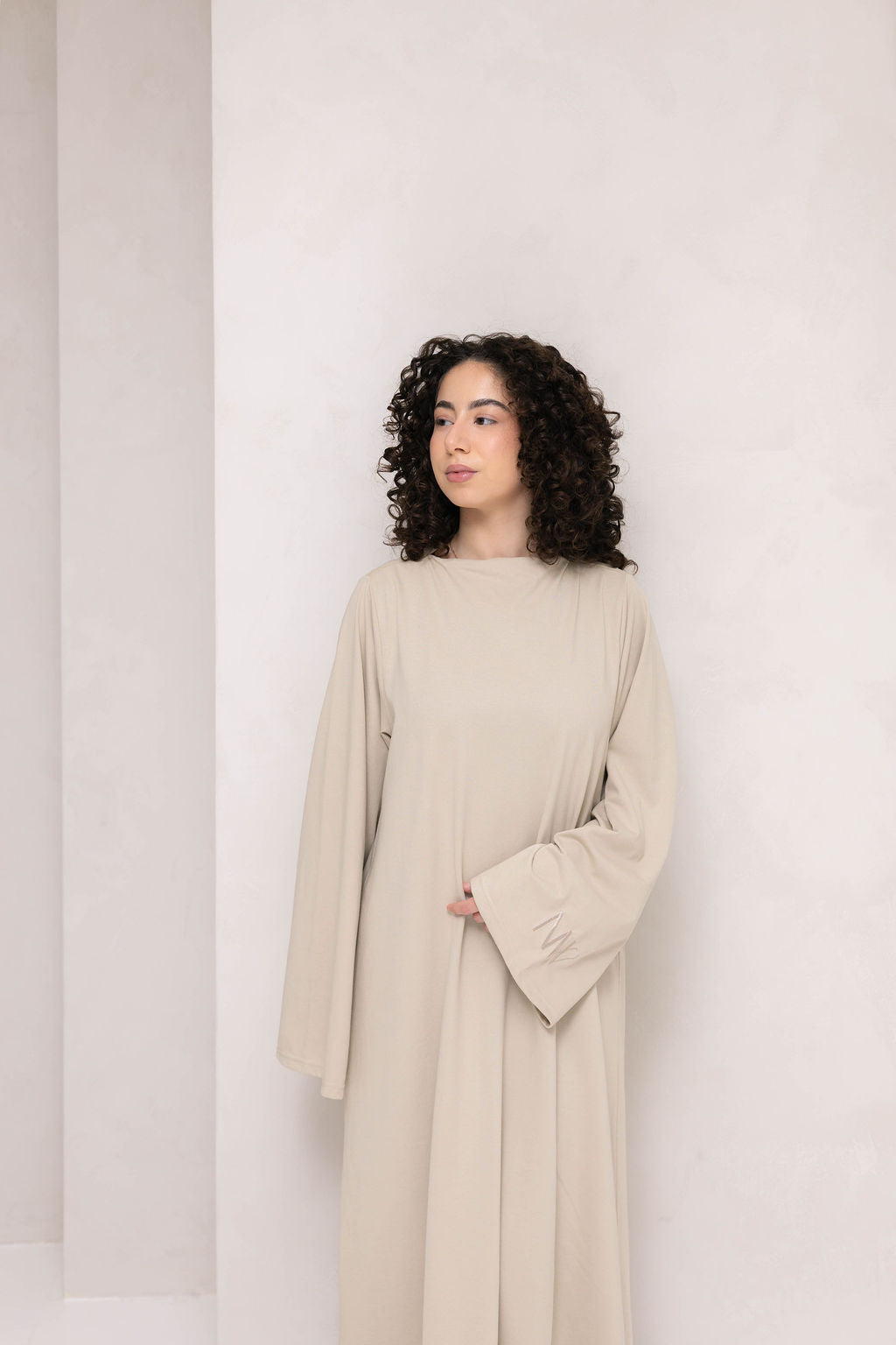 Model wearing eco-friendly abaya dress made of Sorona bio-cotton, lightweight and breathable material in color sage green