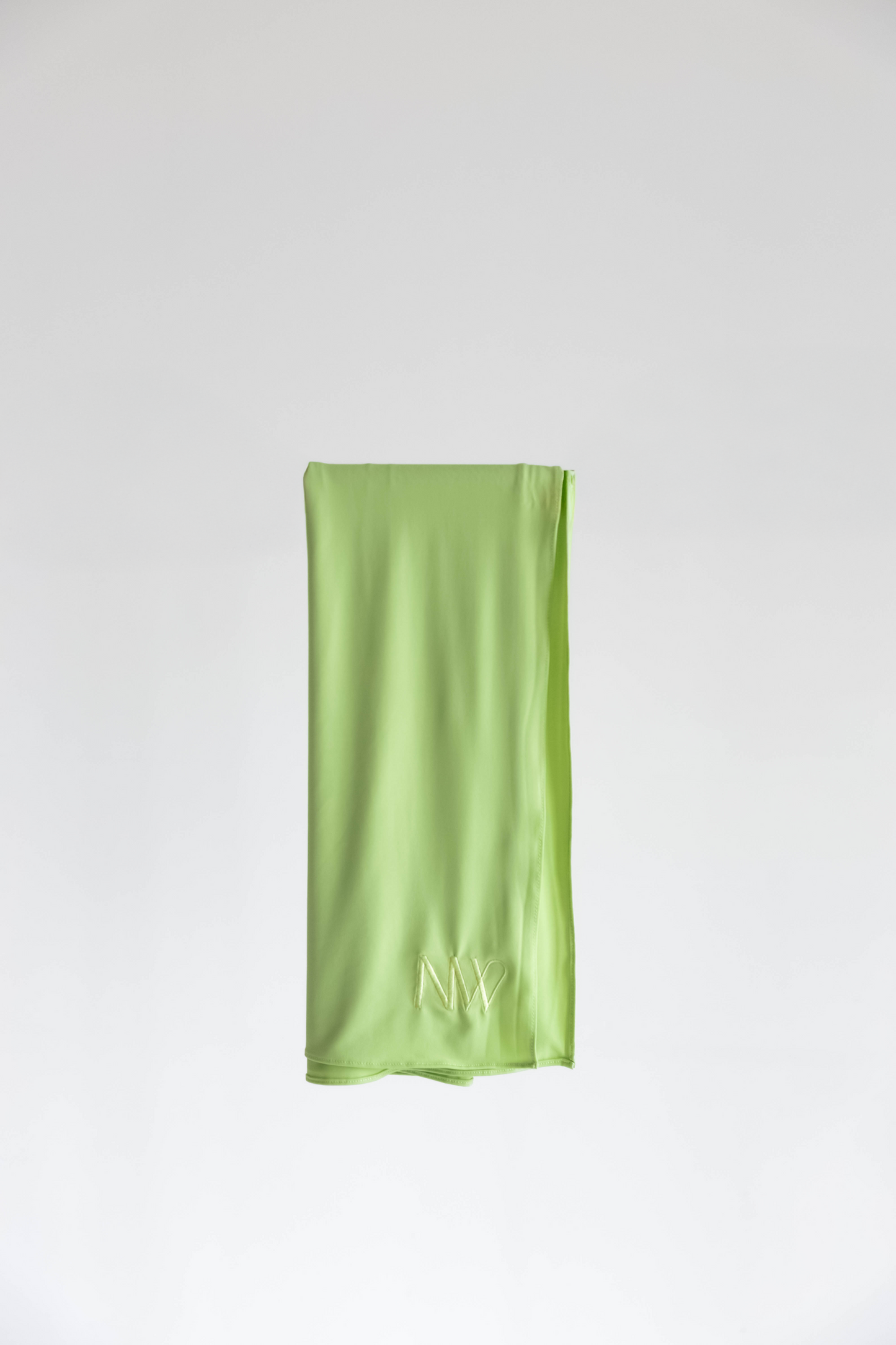 Premium jersey hijab in green by Naleya Wear, folded and displayed on a neutral background