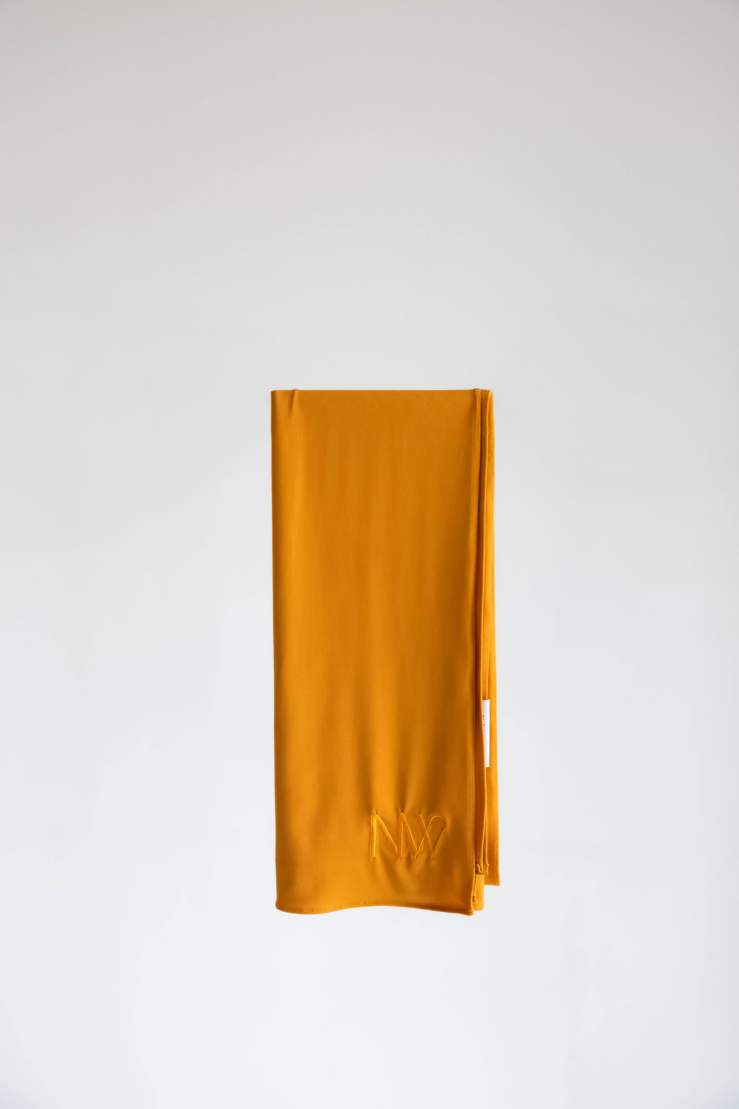 Premium jersey hijab in mustard yellow by Naleya Wear, folded and displayed on a neutral background