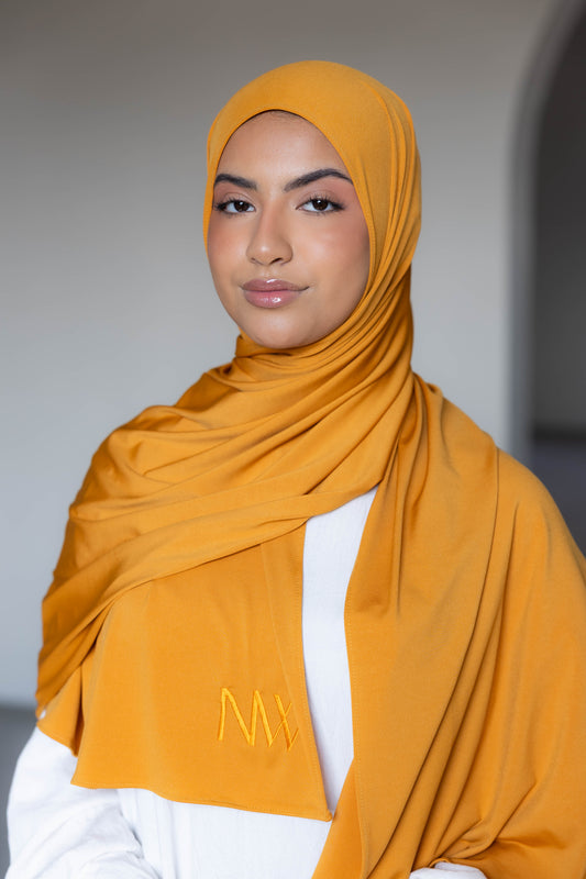 Model wearing a premium jersey hijab in mustard yellow color by Naleya Wear