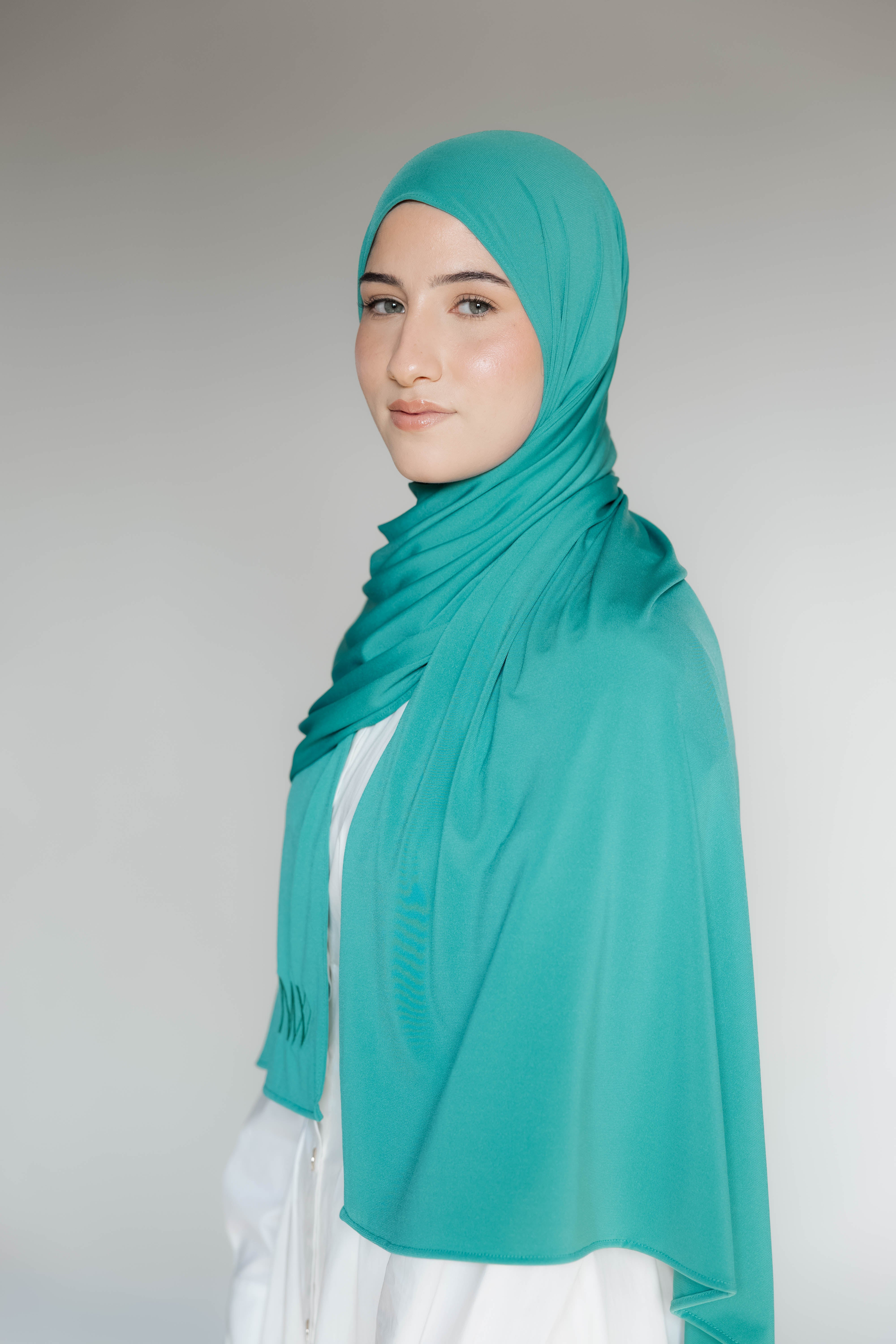 Model wearing a premium jersey hijab in turqouise color by Naleya Wear