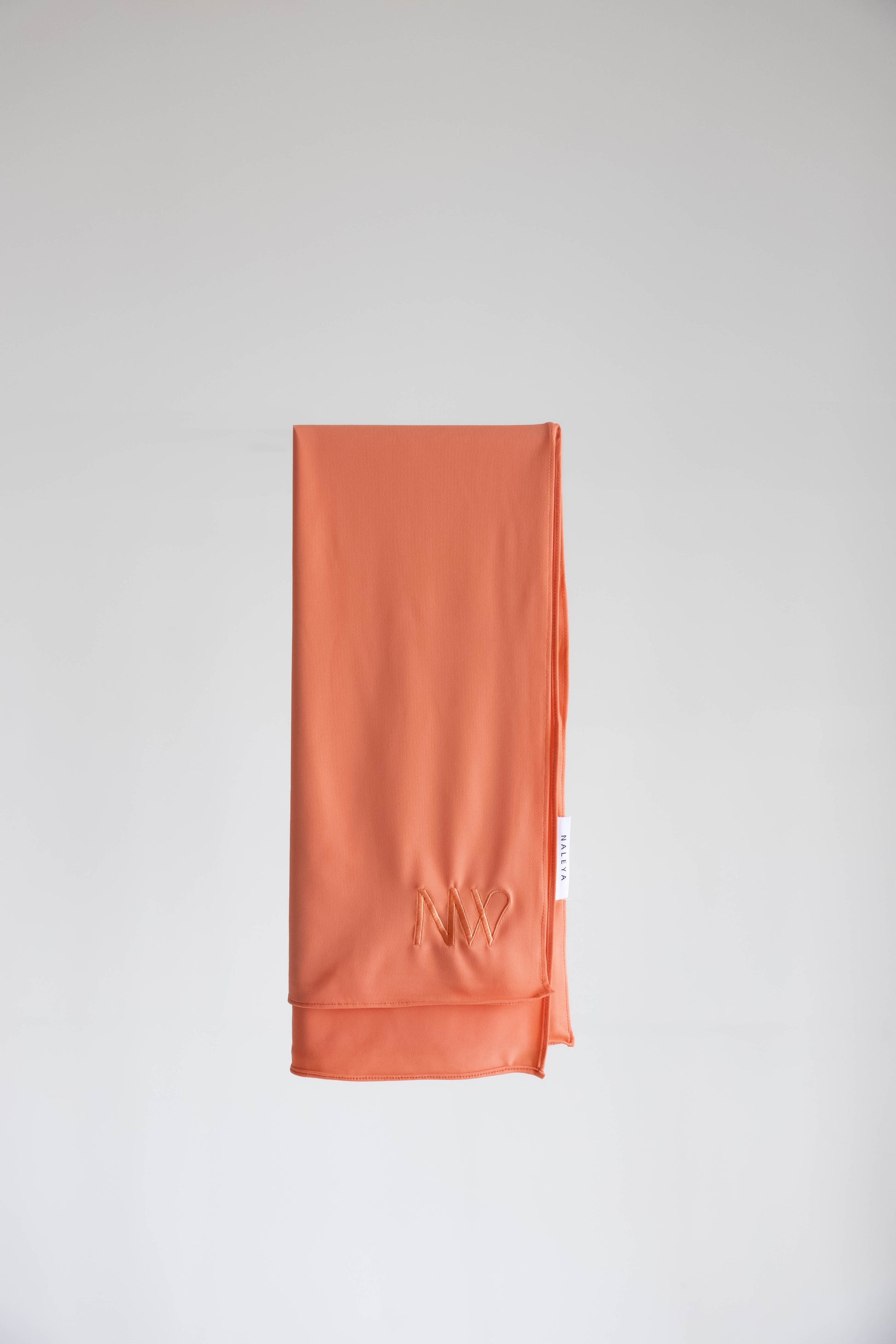 Premium jersey hijab in orange by Naleya Wear, folded and displayed on a neutral background