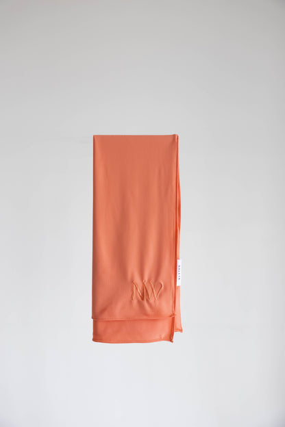 Premium jersey hijab in orange by Naleya Wear, folded and displayed on a neutral background