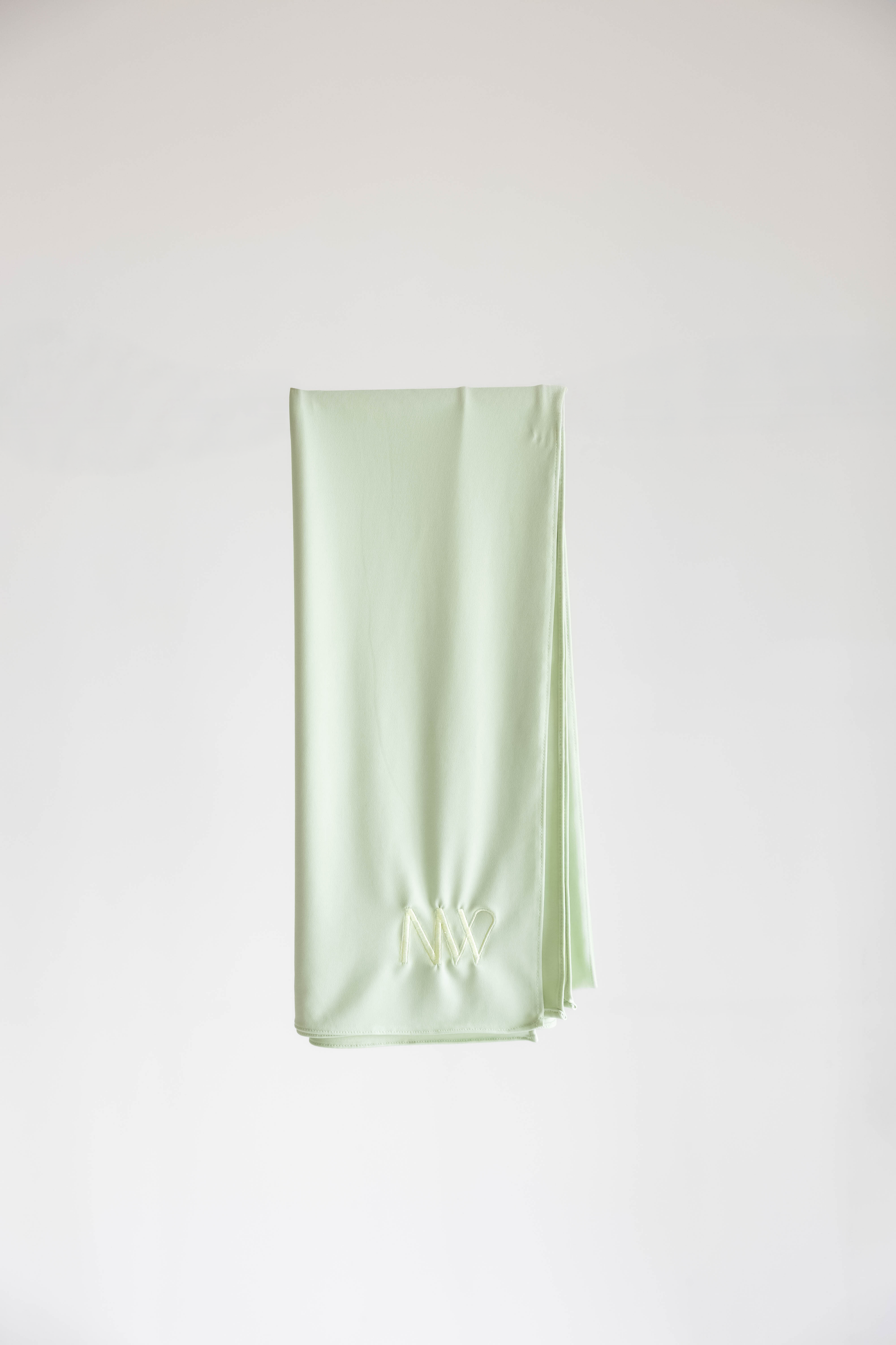 Premium jersey hijab in pastel green by Naleya Wear, folded and displayed on a neutral background