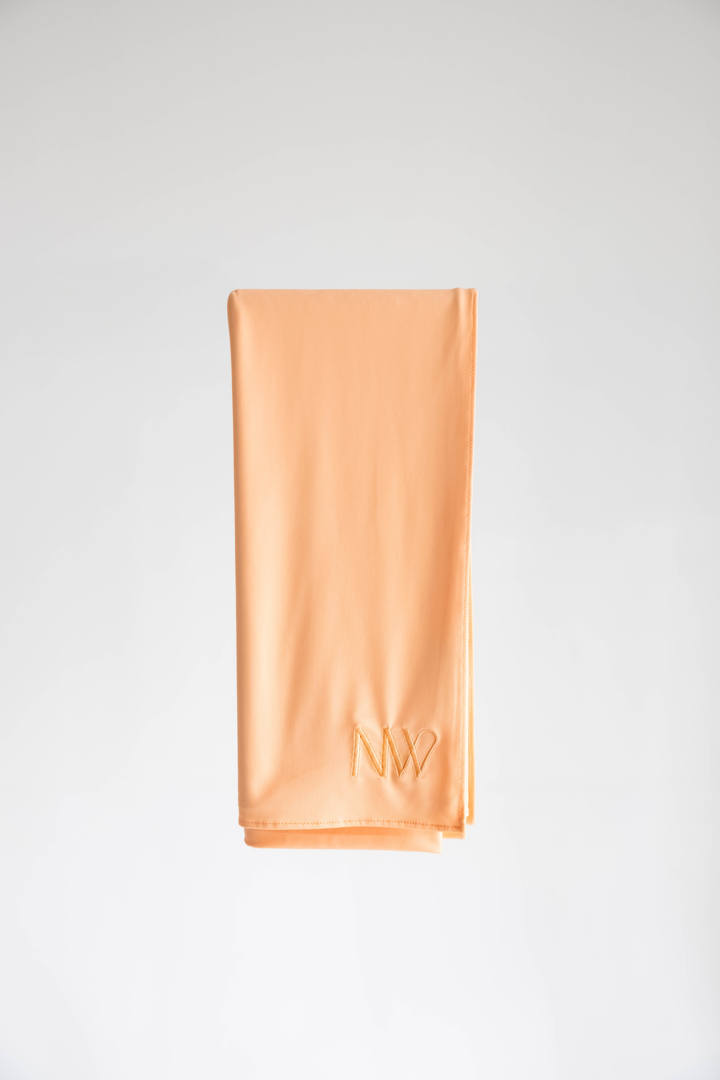 Premium jersey hijab in pastel orange by Naleya Wear, folded and displayed on a neutral background
