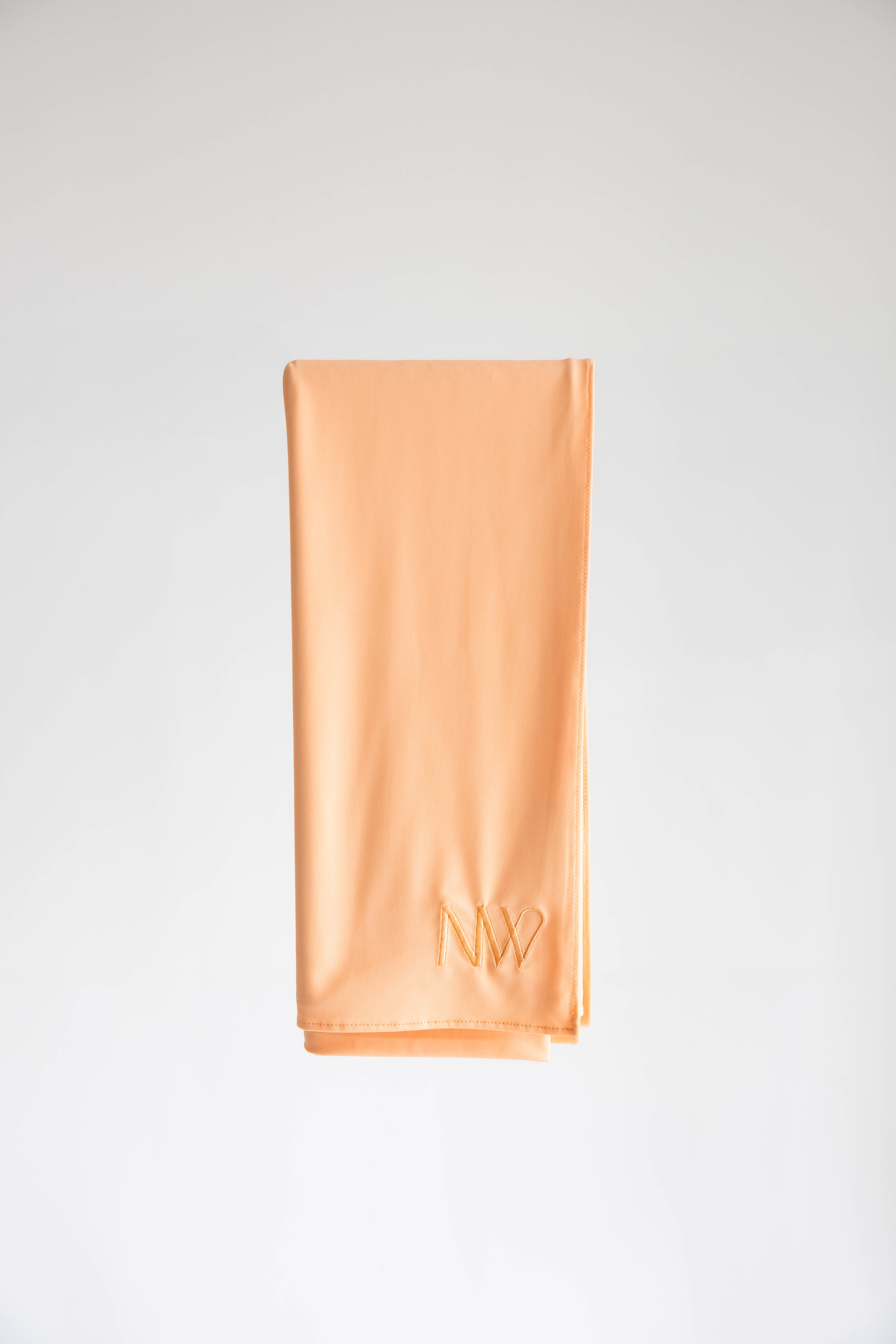 Premium jersey hijab in pastel orange by Naleya Wear, folded and displayed on a neutral background